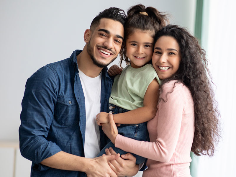 family smiling with young daughter